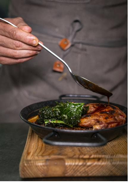 Arroz de pato no forno com uvas e couve crocante em tacho de ferro
